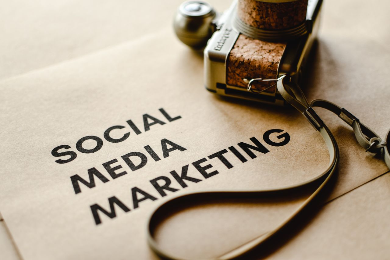 A close-up view of a camera resting on brown paper with the words Social Media Marketing, highlighting themes of digital marketing.