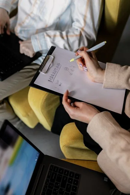 Womans hand writing the word audience on a whiteboard, with arrows.
